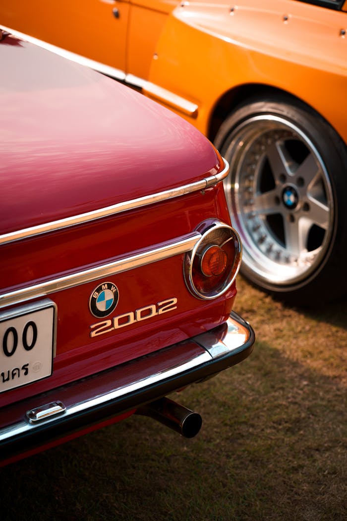 services-02 Close-up of a vintage BMW 2002 with detailed view of its tail light and logo.
